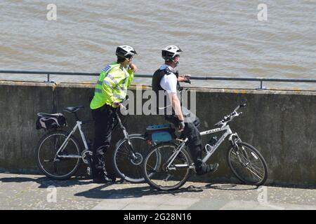 Due ufficiali di polizia da Newham MPS su una pattuglia in bicicletta che visita Gallions Point nella zona dei Royal Docks di Londra Foto Stock