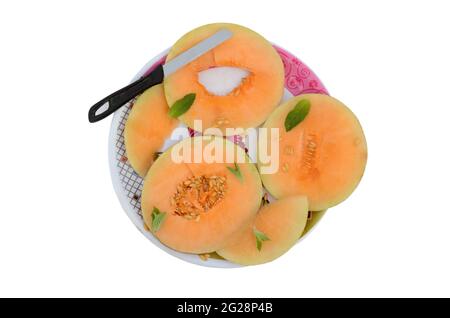 closeup affettato muskmelon arancio maturo con menta e coltello isolato su sfondo bianco. Foto Stock
