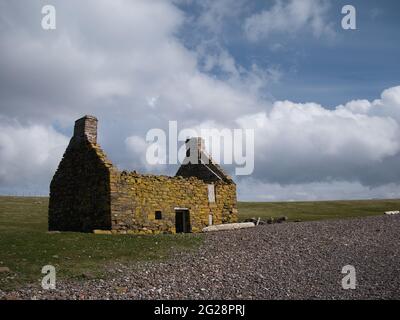 Un abbandonato, derelict croft o fattoria su una spiaggia di ghiaia a Stenness, Northmavine a Shetland, Scozia, Regno Unito Foto Stock