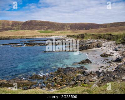 Con acque turchesi, limpide e sabbia bianca, una spiaggia a Collaster sulla costa occidentale dell'isola di Unst a Shetland, Regno Unito - in una tranquilla giornata di sole Foto Stock