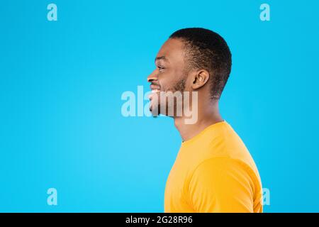 Profilo Ritratto di allegro afroamericano Guy su sfondo Blu Foto Stock