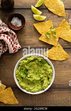 Guacamole caserecce in una ciotola con patatine di tortilla Foto Stock