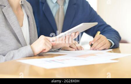 Il successo di consulenti giovani a lavorare come team aziendale in un ufficio analizzando i documenti. Foto Stock