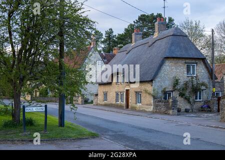 Grazioso cottage con tetto di paglia all'angolo di Hall Close e High Street, Sharnbrook, Bedfordshire, Inghilterra, Regno Unito Foto Stock