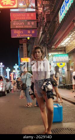 Super modello indossando blusa con le persone sullo sfondo su Yaowarat Road Chinatown Bangkok Thailandia Foto Stock