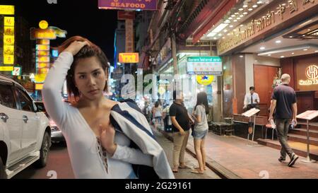 Super modello indossando blusa con le persone sullo sfondo su Yaowarat Road Chinatown Bangkok Thailandia Foto Stock