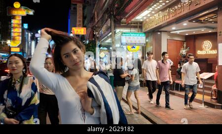 Super modello indossando blusa con le persone sullo sfondo su Yaowarat Road Chinatown Bangkok Thailandia Foto Stock