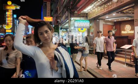 Super modello indossando blusa con le persone sullo sfondo su Yaowarat Road Chinatown Bangkok Thailandia Foto Stock