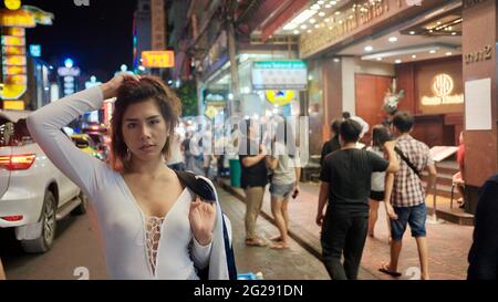 Super modello indossando blusa con le persone sullo sfondo su Yaowarat Road Chinatown Bangkok Thailandia Foto Stock