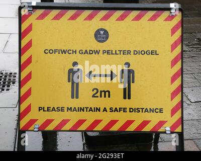 Segnali di avvertimento nel centro di Wrexham durante la pandemia. Segno di allontanamento sociale Foto Stock