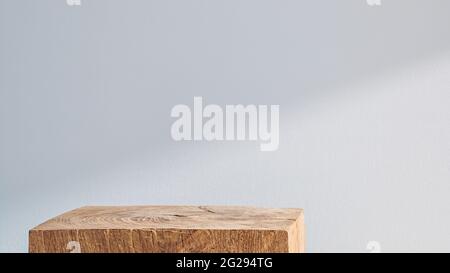 Podio cubico in legno su sfondo bianco con ombra Foto Stock