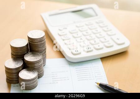 Le monete impilano in colonne con il concetto di finanza del libro di risparmio e di banca per la priorità bassa Foto Stock