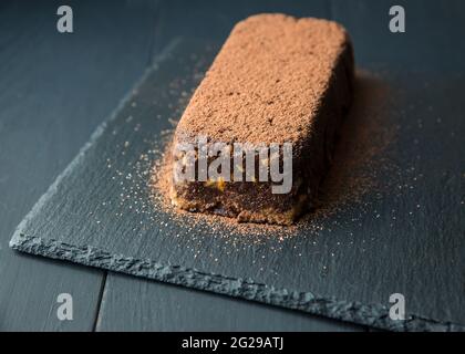 Torta al cioccolato marrone con biscotti sulla piastra nera Foto Stock