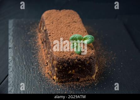 Torta al cioccolato marrone con biscotti sulla piastra nera Foto Stock