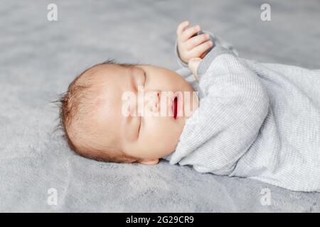 Closeup di sonno asiatico cinese misto razza neonato ragazzo a casa. Foto Stock