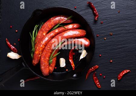 Concept alimentare merguez salsicce piccanti francesi in padella di ferro con spazio per la copia Foto Stock