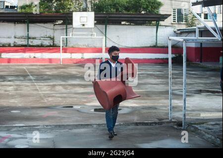 Uno studente porta una scrivania in una classe della Scuola tecnica agricola Eduardo Salazar Gomez. L'Ecuador ha autorizzato il ritorno a classi volontarie in istituzioni private e fiscali, questo è il caso della Scuola tecnica agricola Eduardo Salazar Gomez nella parrocchia di Pifo situata nel nord-ovest della capitale Quito, in questo stabilimento circa 43 studenti del 1 °, 2° grado sono entrati e 3° di Baccalaureate in ogni classe la capacità totale è fino a 12 studenti rispettando la distanza sociale, questa iniziativa risponde alla necessità di molti di questi giovani di poter studiare Foto Stock