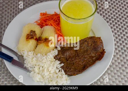 Piatto di cucina brasiliana con bistecca e riso e carote e manioca con un occhio. Pranzo executive. Cibo fatto in casa e stagionato. Arrosto di manzo con salsa e sa Foto Stock