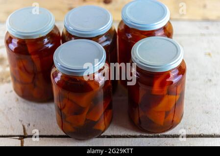 Bicchieri di marmellata con marmellata di zucca fatta in casa su sfondo di legno. Deliziosa e gustosa marmellata di zucca a pezzi. Marmellate fatte in casa. Cucina brasiliana. Dessert. Foto Stock