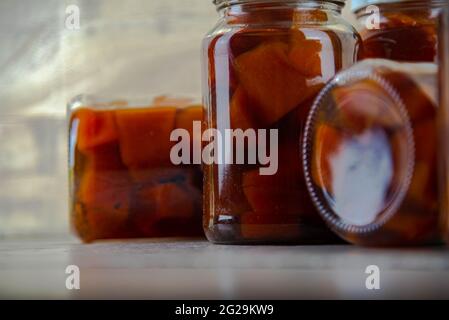 Bicchieri di marmellata con marmellata di zucca fatta in casa su sfondo di legno. Deliziosa e gustosa marmellata di zucca a pezzi. Marmellate fatte in casa. Cucina brasiliana. Dessert. Foto Stock