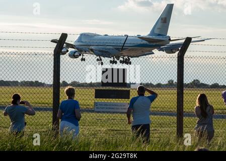 RAF Mildenhall, Suffolk, Regno Unito. 9 Giu 2021. Il presidente DEGLI STATI UNITI Joe Biden è volato da Washington a RAF Mildenhall a Suffolk a bordo di "Air Force One", un Boeing VC-25A (convertito Jumbo Jet del 747), atterrando in prima serata. La base aerea è utilizzata dalla centesima ala di rifornimento dell'aria dell'aeronautica degli Stati Uniti, il cui personale di stanza sarà ispezionato da Biden come primo evento programmato della sua visita di cinque giorni nel Regno Unito. Biden partirà più tardi in serata per trasferirsi in occasione di incontri con il PM Boris Johnson e per partecipare al vertice del G7 in Cornovaglia. Persone che guardano l'AF1 da dietro la recinzione di sicurezza perimetrale Foto Stock