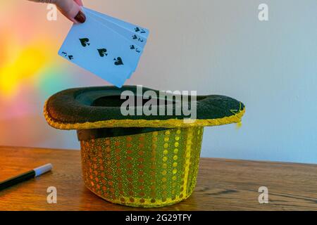 Magic show maghi trucco concetto sfondo. Scatola magica per bambini con cappelli in paillettes, bacchetta magica, carte da gioco, trucco con coppa e palla, disegno segreto Foto Stock