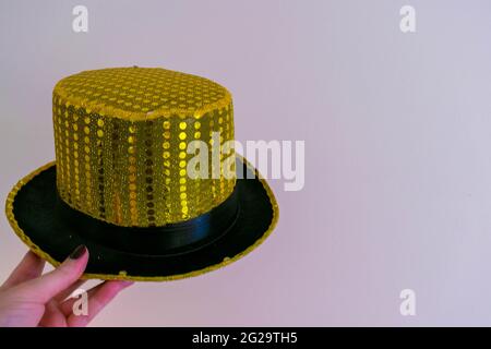 Cappellino in paillettes giallo oro magico su sfondo isolato con spazio per copiare il testo. Spettacolo di maghi, sfondo di concetto di trucchi magici. Fantasia Foto Stock