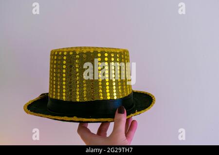Cappellino in paillettes giallo oro magico su sfondo isolato con spazio per copiare il testo. Spettacolo di maghi, sfondo di concetto di trucchi magici. Fantasia Foto Stock