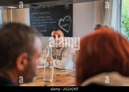 Gente gioiosa che passa il tempo e si diverta a tavola con i bicchieri che celebrano in una stanza luminosa Foto Stock