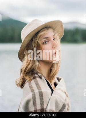 Barba grigia di rasatura con barbiere maschio non riconoscibile e basso angolo di coltura di cliente elegante di mezza età in occhiali seduti vicino a specchio in parrucchiere Foto Stock