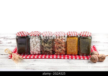 Cibo sano in vasi di vetro. Grani, semi, legumi, spezie. Su un tavolo di legno. Cibo pulito, vegano, dieta concetto di cibo Foto Stock