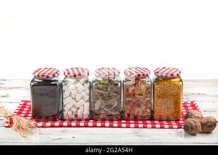 Cibo sano in vasi di vetro. Grani, semi, legumi, spezie. Su un tavolo di legno. Cibo pulito, vegano, dieta concetto di cibo Foto Stock