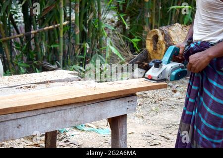 Piallatrice elettrica per legno , uomo al lavoro con legno e macchina Foto  stock - Alamy