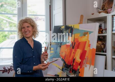 Donna pittore di disegni, si prepara a creare un'immagine astratta sul quadro. Nel proprio atelier della galleria, studio. Foto Stock