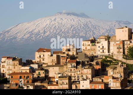 Vista abitativa della città rurale di Centuripe sullo sfondo del vulcano Etna parzialmente innevato, Sicilia, Italia Foto Stock