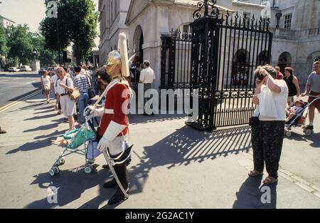 Estate nella città di Londra: I turisti scattano foto di un Trooper of the Life Guards di fronte alla Horse Guards Parade. Foto Stock
