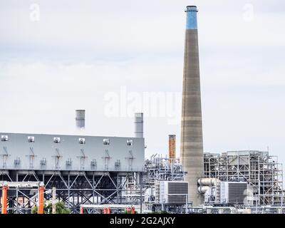 Nuova centrale a gas naturale a ciclo combinato sulla sinistra (condensatore raffreddato ad aria, prese d'aria nella parte anteriore); vecchia centrale a gas naturale in pensione Foto Stock