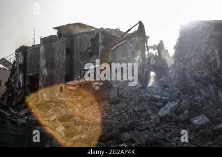 I lavoratori palestinesi e i bulldozer con l'aiuto di equipaggi egiziani rimuovono le macerie degli edifici distrutti dagli attacchi aerei israeliani il mese scorso, nella città di Gaza il 9 giugno 2021. Foto di Habboub Ramez/ABACAPRESS.COM Foto Stock