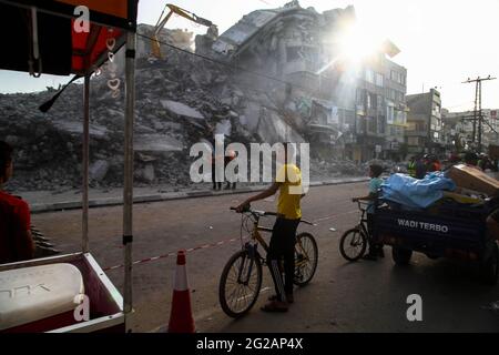 I lavoratori palestinesi e i bulldozer con l'aiuto di equipaggi egiziani rimuovono le macerie degli edifici distrutti dagli attacchi aerei israeliani il mese scorso, nella città di Gaza il 9 giugno 2021. Foto di Habboub Ramez/ABACAPRESS.COM Foto Stock