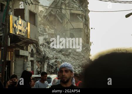 I lavoratori palestinesi e i bulldozer con l'aiuto di equipaggi egiziani rimuovono le macerie degli edifici distrutti dagli attacchi aerei israeliani il mese scorso, nella città di Gaza il 9 giugno 2021. Foto di Habboub Ramez/ABACAPRESS.COM Foto Stock