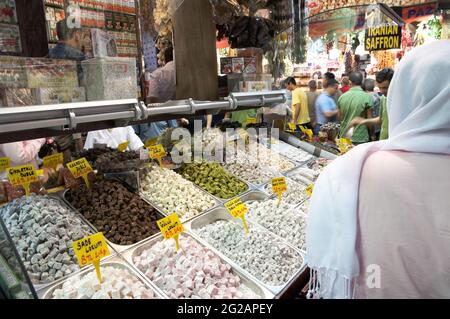 Istanbul, Turchia - 19 luglio 2010: Negozio di delizia turca o 'lokum' nel Grand Bazaar di Istanbul, in primo piano vista posteriore di una donna musulmana con t Foto Stock