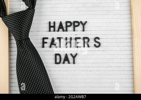 Lavagna con lettere di congratulazioni scritta Happy Father's Day e accessorio cravatta da uomo. Foto Stock