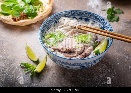 Zuppa di tagliatelle di riso con manzo ed erbe o pho bo vietnamita, fuoco selettivo Foto Stock