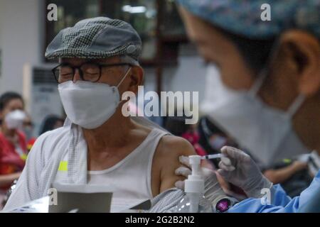 Giacarta, Indonesia. 10 Giugno 2021. Un operatore sanitario inocula un uomo con una dose del vaccino COVID-19 a Giacarta, Indonesia, 10 giugno 2021. Credit: Veri Sanovri/Xinhua/Alamy Live News Foto Stock