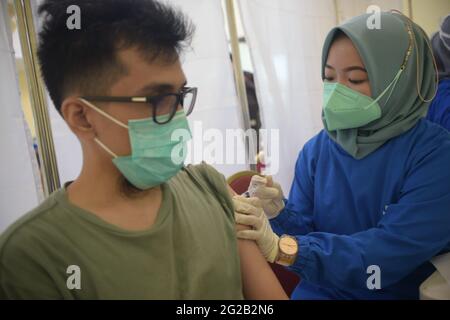 Giacarta, Indonesia. 10 Giugno 2021. Un operatore sanitario inocula un uomo con una dose del vaccino AstraZeneca COVID-19 a Giacarta, Indonesia, 10 giugno 2021. Credit: Zulkarnain/Xinhua/Alamy Live News Foto Stock