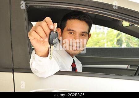 Uomo d'affari che dà la chiave dell'automobile Foto Stock