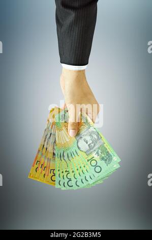 Uomini d'affari che detengono denaro - dollari australiani (AUD) Foto Stock