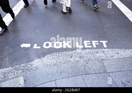 Cartello 'LOOK LEFT' sulla strada in Australia Foto Stock