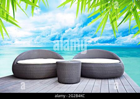 Salotto in rattan accanto al mare Foto Stock