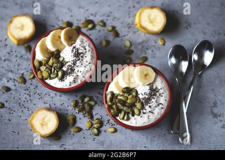 Ciotole con budino di chia con banana e semi di zucca. Foto Stock